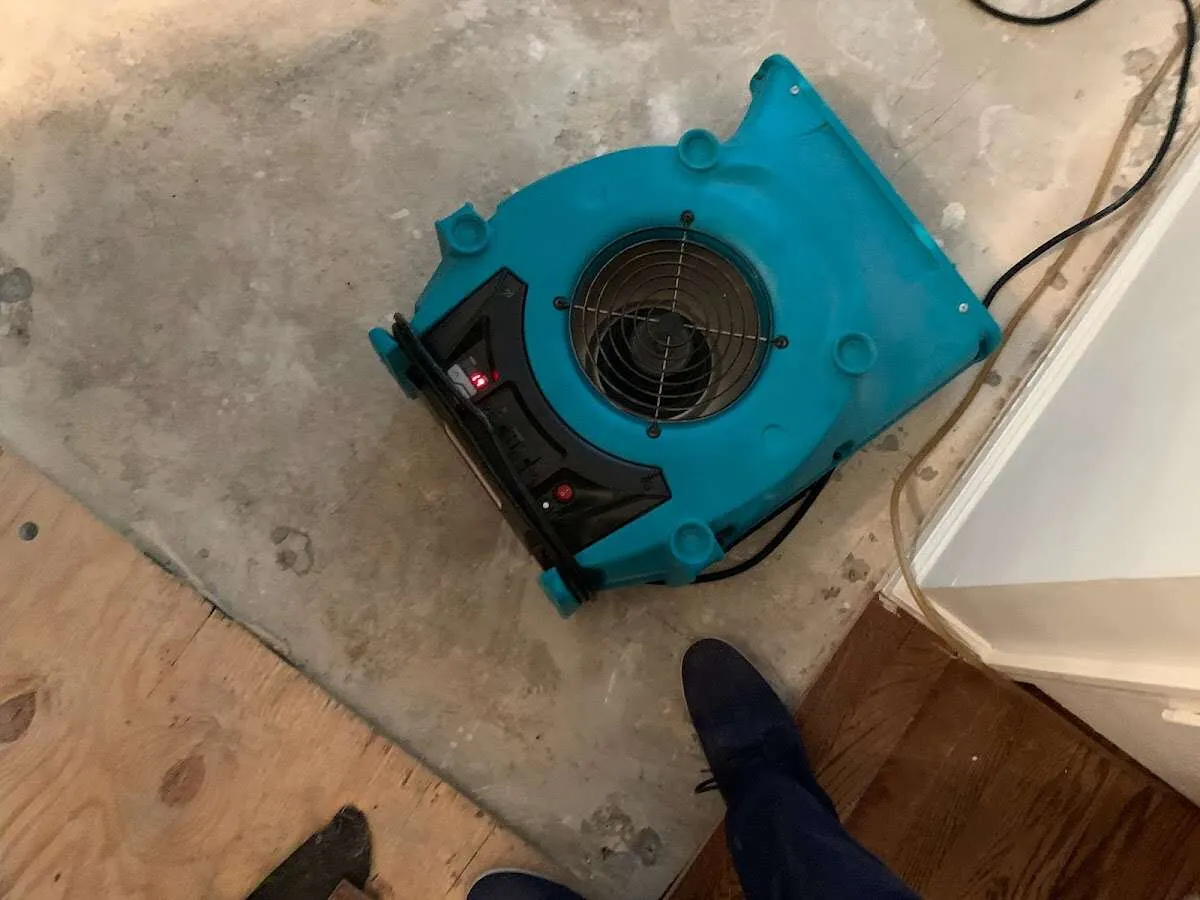Air mover drying subfloor during Commercial Water Damage Restoration in Dubuque